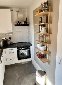 a kitchen with white cabinets and a black oven at Modern, gemütlich, sehr zentrumsnah & ruhig in Leipzig