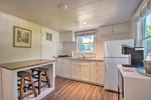 uma cozinha com armários brancos e um frigorífico branco em Cozy Athens Cottage Walk to Sanford Stadium! em Athens