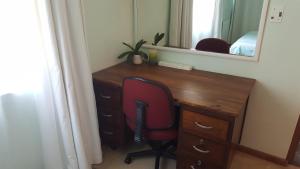 escritorio con silla roja frente a un espejo en Durbanville Place - 3 bedroom apartment, en Durbanville