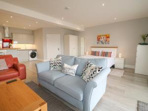 a living room with a couch and a kitchen at Slitting Mill Annex in Rugeley