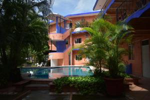 un edificio con piscina frente a un edificio en Hotel Y Bungalows Islas Careyes, en Los Ayala