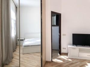 a mirror in a room with a bed and a television at Аpartment near Central Vokzal in Minsk