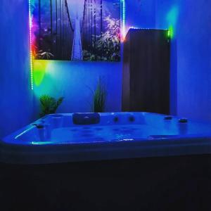 Baño azul con bañera con luces. en Maison avec jacuzzi, en Saint-Mitre-les-Remparts