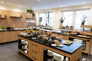 a kitchen with a large island with dishes on it at Stadthotel Lichtenfels in Lichtenfels
