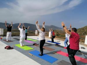 a group of people doing yoga on a roof at Cortijo Samadhi in Lanjarón