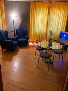 sala de estar con mesa, sillas y TV en Home Relax en Cagliari
