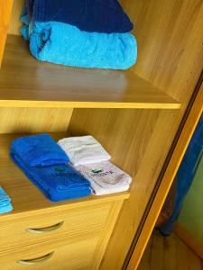 a wooden shelf with blue towels and towels at Home Relax in Cagliari +22 photos