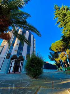 a building with a palm tree in front of it at Home Relax in Cagliari
