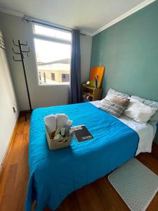 Habitación cómoda y céntrica في غواتيمالا: غرفة نوم بسرير وبطانية زرقاء ونافذة