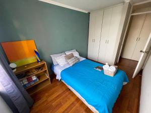 Dormitorio pequeño con cama azul y armarios blancos en Habitación cómoda y céntrica, en Guatemala