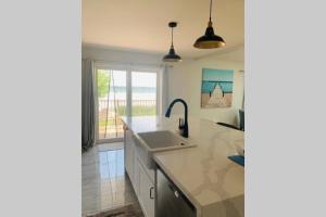 a kitchen with a sink and a view of the ocean at Luxury Lakefront 4-Bedroom Cottage with Great Outdoor Space and Private Dock in Kawartha Lakes