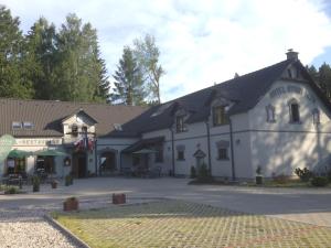a large white building with a black roof at Hotel Starý Mlýn in Mlýnec