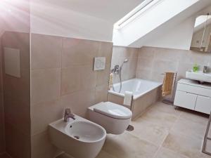 a bathroom with a toilet and a sink and a bath tub at Schlossseeapartment in Salem