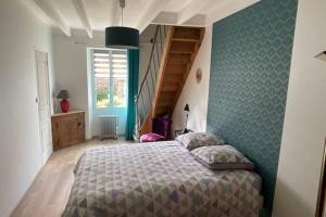 een slaapkamer met een bed met een groene muur bij Gîte en Cotentin in Étienville