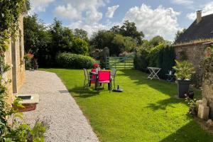 a woman sitting at a table in a garden at Gîte en Cotentin in Étienville +5 photos