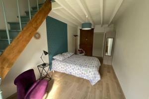 a small bedroom with a bed and a staircase at Gîte en Cotentin in Étienville