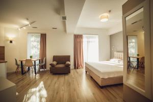 a bedroom with a bed and a table and a chair at Sunrise Aparts in Polyana