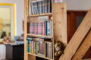 a wooden book shelf filled with books and a teddy bear at Traumhafte Ferienwohnung in Ratzeburg