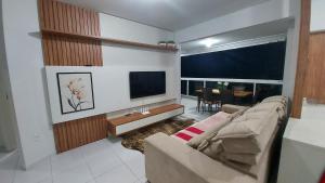 a living room with a couch and a flat screen tv at RESIDENCIAL BORBOLETAS DO MAR in Bombinhas