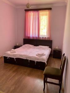 a bedroom with a bed and a chair and a window at Noravank B&B in Chʼiva