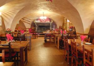 a restaurant with wooden tables and chairs and a fireplace at La Vieille Auberge in Vars