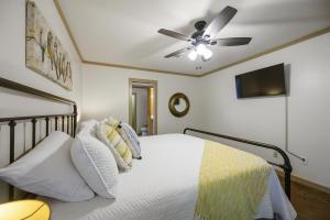 - une chambre avec un lit et un ventilateur de plafond dans l'établissement Coper Fox with Hot Tub and BBQ, à Broken Bow