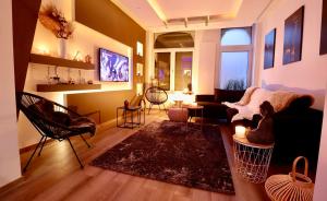 a living room with a couch and a table and a tv at SuiteDreams - Bubble Suite Liège in Liège