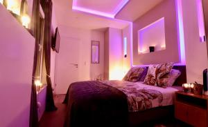 una camera con un letto con luci viola di SuiteDreams - Bubble Suite Liège a Liegi