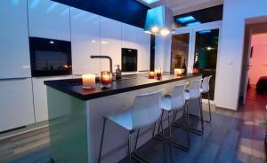 a kitchen with a bar with white bar stools at SuiteDreams - Bubble Suite Liège in Liège