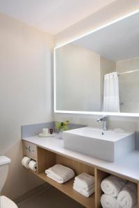 uma casa de banho com um lavatório branco e um espelho. em BEI San Francisco, Trademark Collection by Wyndham em São Francisco