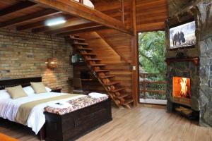sypialnia z dużym łóżkiem i kominkiem w obiekcie Luxury cabin surrounded by nature w mieście Baeza