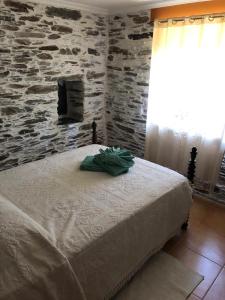 a bedroom with a bed with a stone wall at Cantinho Casal do Rei in Seia