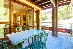a table and chairs on the porch of a house at Spacious Family 2-bed, 2-bath with parking, private piste in Flaine