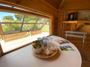 una mesa pequeña en una cabaña con ventana en Résidence Romaric, en Jard-sur-Mer