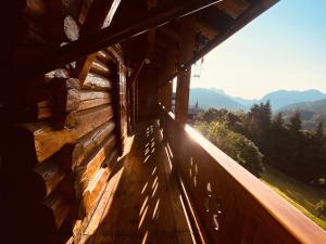 CHALET PA MAURAR Sauris في Sauris di Sopra: شرفة خشبية لكابينة مطلة على الجبال
