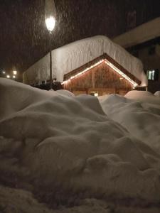 une pile de neige devant un bâtiment dans l'établissement CHALET PA MAURAR Sauris, à Sauris di Sopra