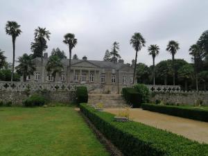 an old house with palm trees in front of it at Royal Castel mobile home in Quimper