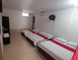 a hotel room with two beds and a fan at Hotel Gueicer Cucuta in Cúcuta