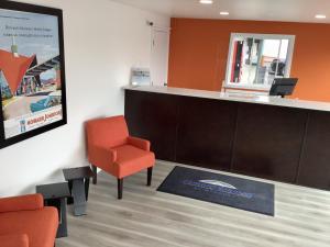 una sala de espera con una silla naranja y un mostrador en Howard Johnson by Wyndham Spokane en Spokane