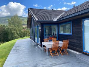 eine Terrasse mit einem Tisch und Stühlen auf einem Haus in der Unterkunft Dyrhaug - hytte med utsikt over Krøderen in Noresund