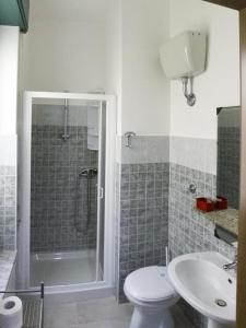 y baño con ducha, aseo y lavamanos. en Torre Del Pozzo en S'archittu Cuglieri