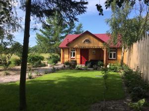 une maison avec un toit rouge et une cour dans l'établissement Chata 3 Drogi, à Janów Podlaski