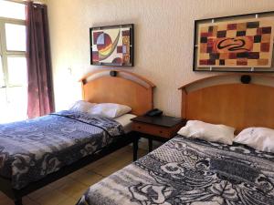 Habitación de hotel con 2 camas y ventana en Hotel Regis en Monterrey