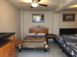 1 dormitorio con 2 camas y ventilador de techo en Hotel Regis en Monterrey