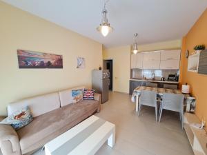 a living room with a couch and a kitchen at Holiday One Bedroom Sea View Apartment Vlore in Vlorë