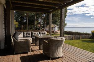 a porch with a couch and chairs and a table at Pilėja in Neringa