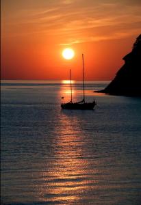 una barca a vela nell'oceano al tramonto di Latitudes 43 a Porquerolles
