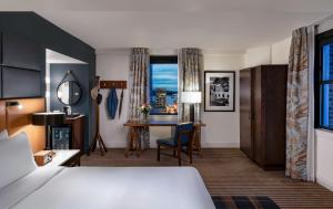 シアトルにあるホテル セオドアのベッドとデスクが備わるホテルルームです。