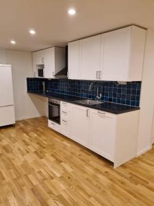 an empty kitchen with white cabinets and blue tiles at Pearl of Duved in Duved
