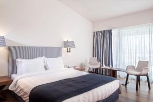 a hotel room with a bed and a desk and a window at Horizon Blu Boutique Hotel in Kalamata